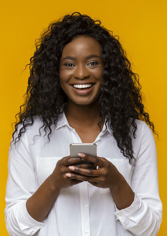 Mulher sorrindo com um smartphone em mãos